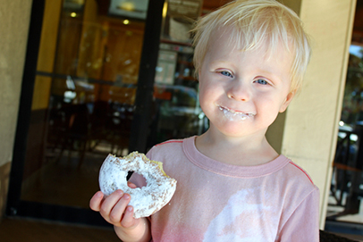 http://www.dreamstime.com/stock-photos-happy-young-child-eating-doughnut-coffee-shop-standing-outside-eatiing-powdered-shugar-image37383643