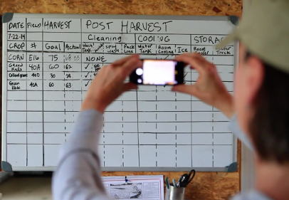 Farmer-photographing-white-board-records