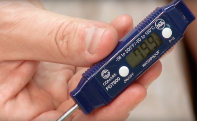 man holding food thermometer