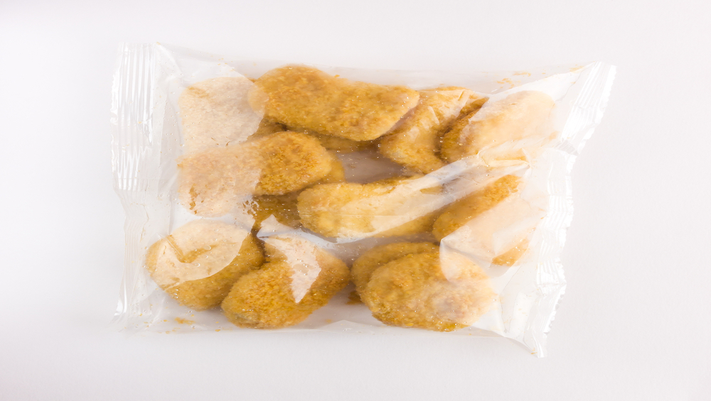 Frozen nuggets in the package. Frozen nuggets from a shop in a package on a white background.