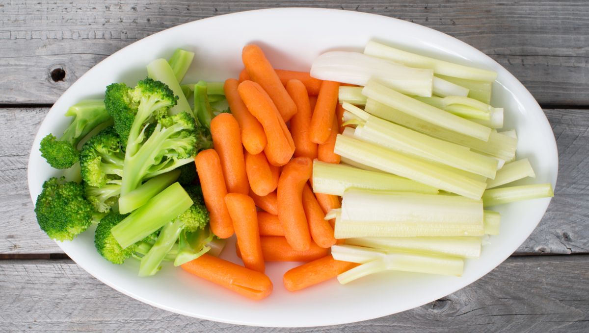 Vegetable tray with celery, broccoli, carrots on a wooden table